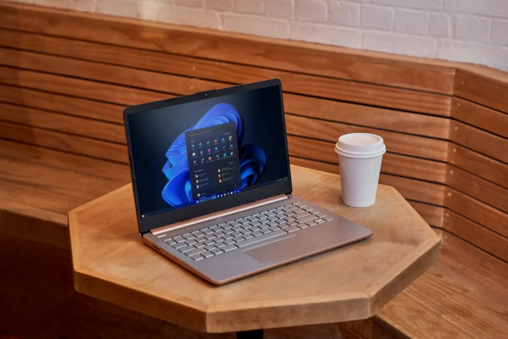 Windows 11 laptop a legújabb frissítéssel, asztalon kávéval, fejlesztett teljesítményt mutatva.